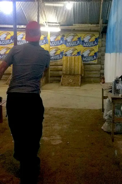 Man aiming at clay target with a weight while playing Tejo in Salento, Colombia.