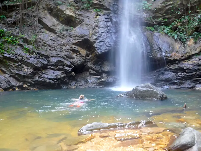 Girl swimming up to the bottom of Avocat Waterfall, Trinidad