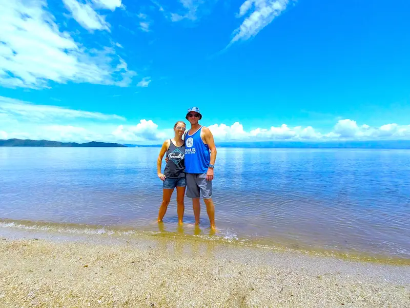 Couple standing in shallow water in a calm, blue beach on Costa Rica's Nicoya Peninsula.