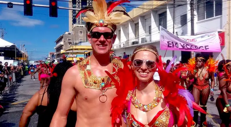 Man and woman in Trinidad Carnival costume with beads and feathers in the parade through Port of Spain.