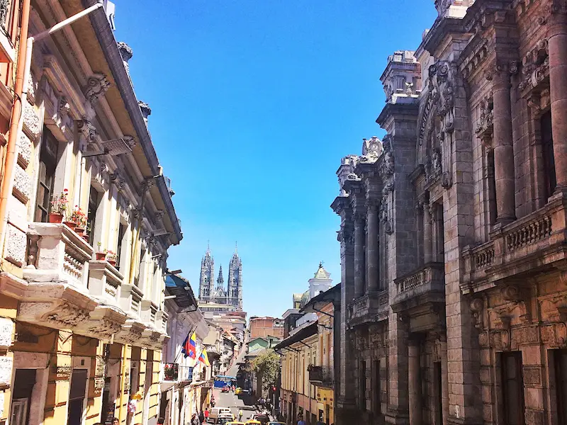 Looking down a colonial street to large cathedral in Quito Ecuador.