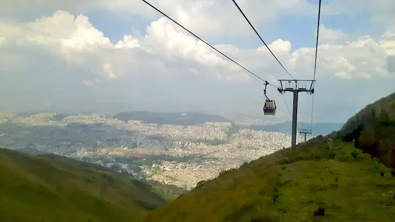 Cable car high in the air above the mountains and city views of Quito Ecuador.