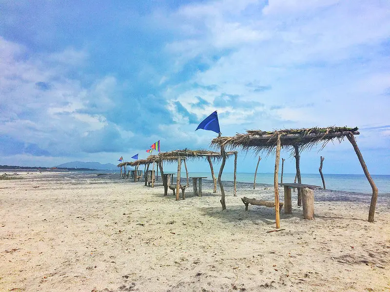 Row of palapa shelters along a deserted beach in San Carlos, Panama.