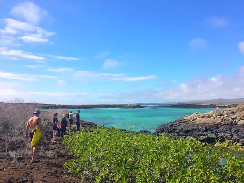 Bright blue water of a shark-filled lagoon with a group about snorkel on San Cristobal, Galapagos