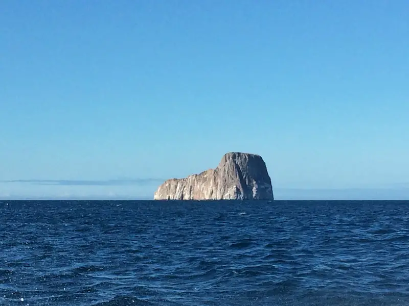 A tall rock formation surrounded by ocean called Kicker Rock off the coast of Isla San Cristobal, Galapagos Islands, Ecuador