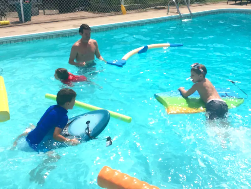 Terry playing with 3 nephews in an outdoor pool.