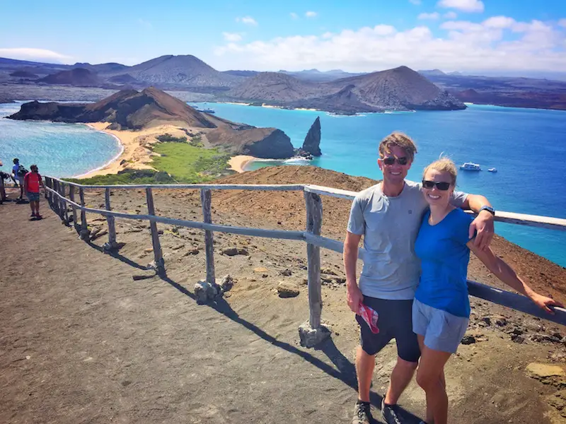 Couple standing at top of hike to Pinnacle Rock viewpoint in Galapagos Islands.