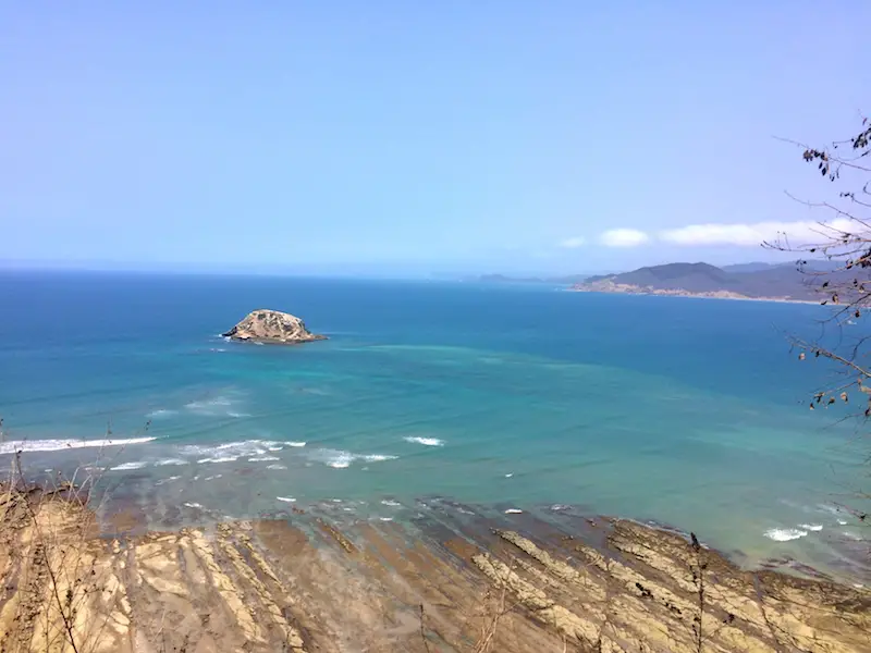 Looking across jagged rocks to the turquoise Pacific Ocean from the mirador at Playa los Frailes, Ecuador.