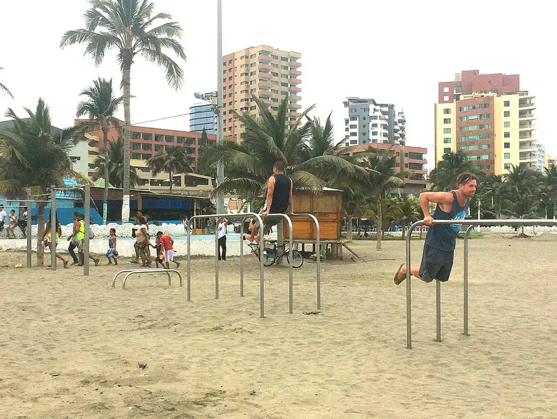 Men working out on the bars at Playa Murcielago, Manta, Ecuador.