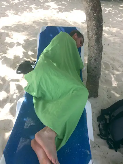 Terry curled up under a towel on a sun lounger, sick with Dengue fever in Barbados.