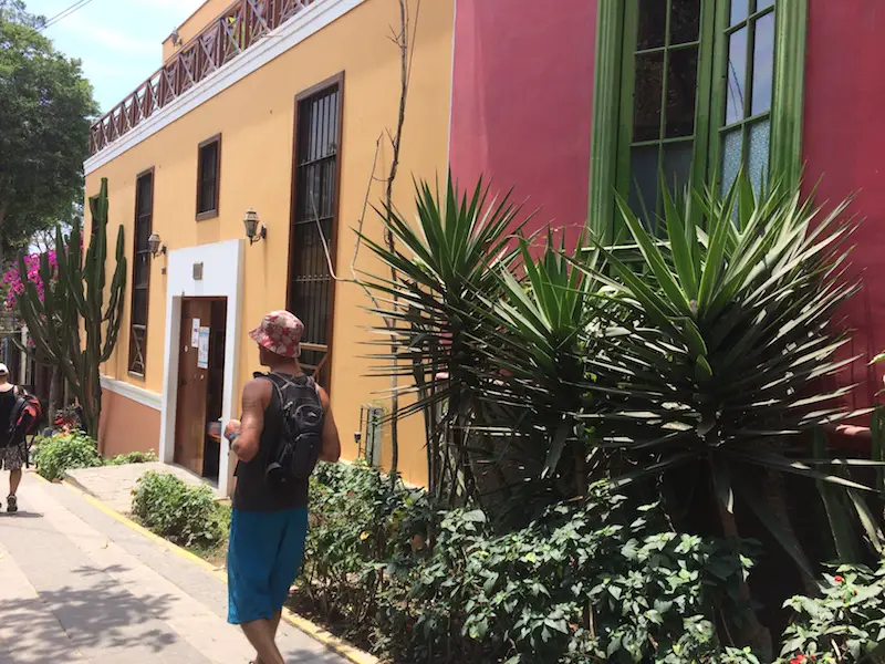 Man walking down a colourful street in Barranco, Lima.