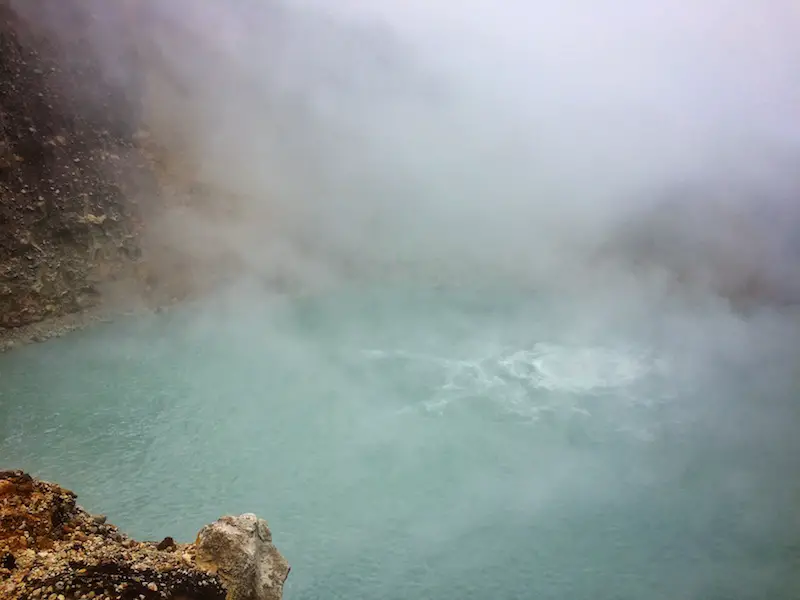 A blue water bubbling and obscured by steam in Dominica.