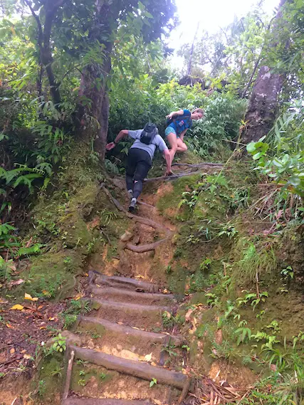 Couple climbing up steep steps on hike to Boiling Lake, Dominica.