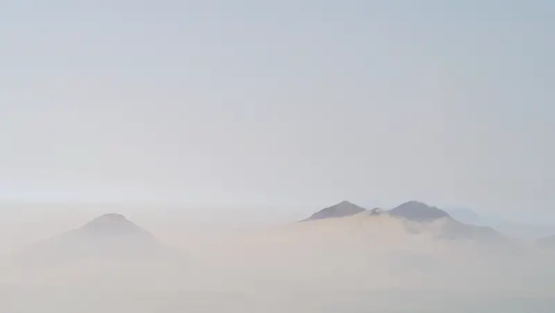 Mountain peaks showing through a hazy landscape in Peru.