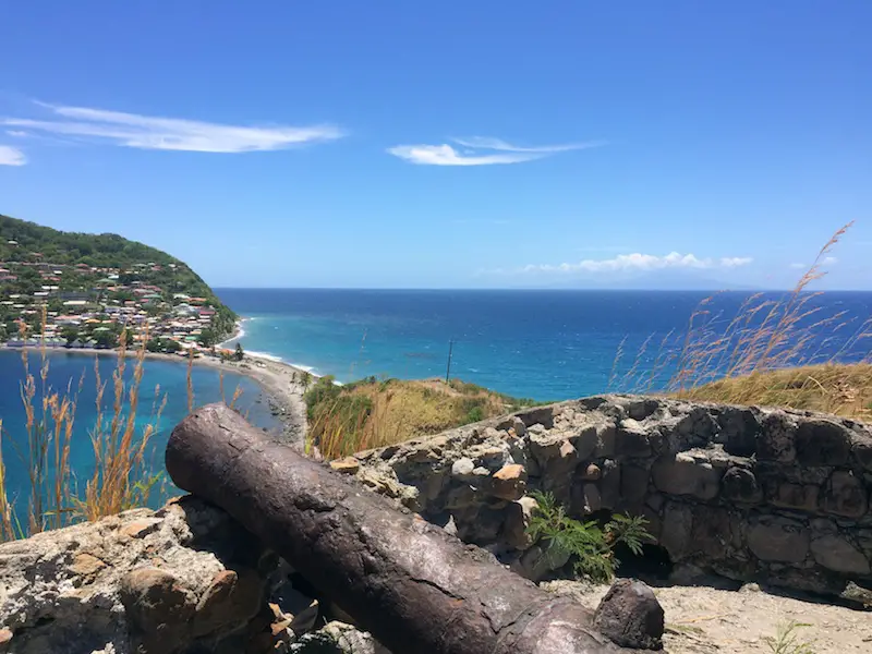 Rusted canon up high on a headland overlooking Caribbean Sea in Dominica.