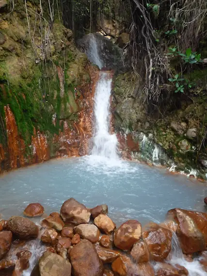 Milky, blue water at the bottom of a small sulphur hot spring waterfall on Boiling Lake hike, Dominica.