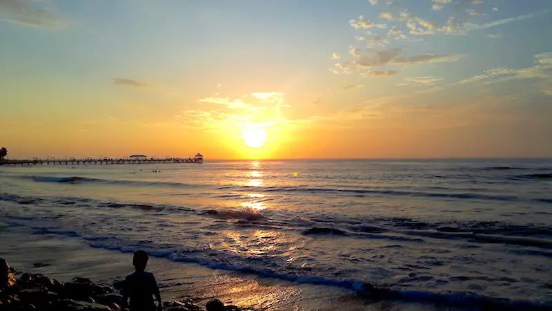 Sunset over the Pacific Ocean looking at the pier in Huanchaco, Peru.