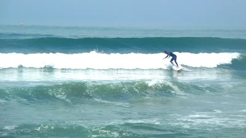 Man surfing in wetsuit in Huanchaco, Peru.