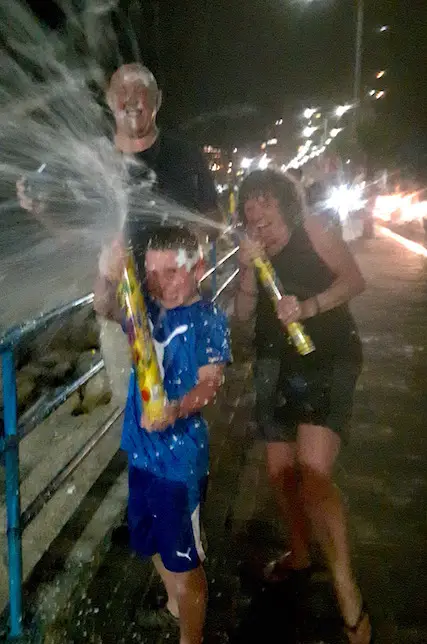 Family spraying foam at photographer during carnival celebrations, Salinas Ecuador.