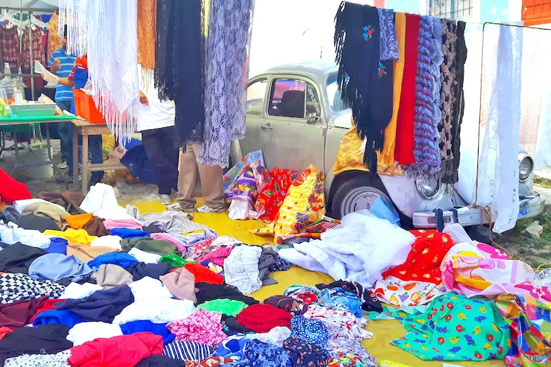 Clothes draped all over an old Volkswagen Beetle at Chapala Market, Mexico.