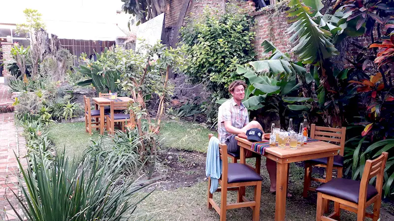 Man sitting at a table in a tropical courtyard in Ajijic restaurant, Mexico.