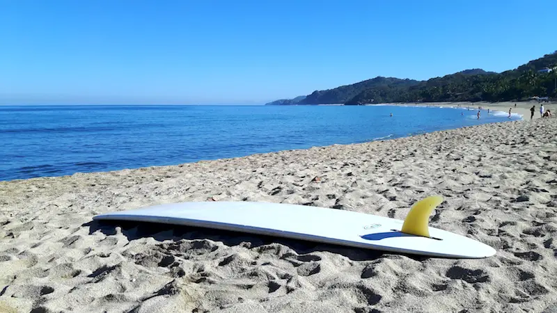 White surfboard laying upside down waiting to go surfing - one of the best things to do in Sayulita Mexico.