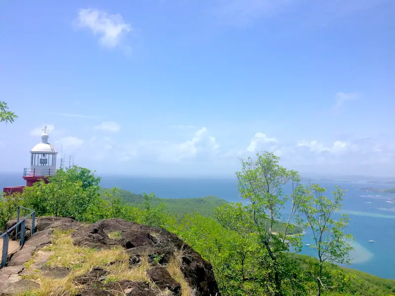 Lighthouse on cliff edge with Caribbean Sea in background, Martinique.