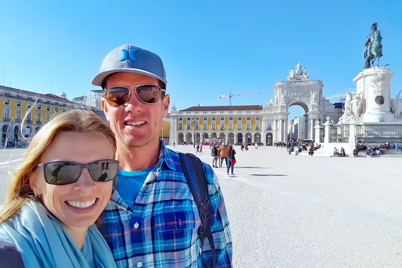 Man and woman in a large open plaza in Lisbon Portugal.