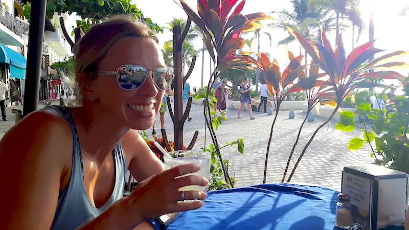 Woman drinking a $1 margarita on boardwalk of Puerto Vallarta, Mexico.