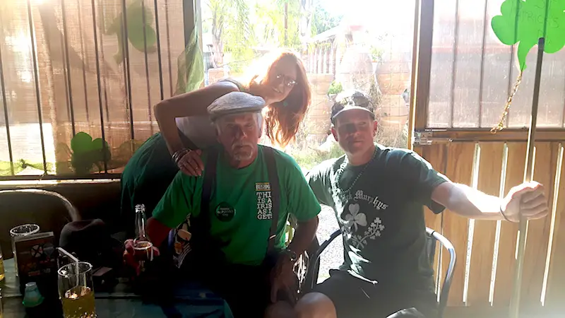 Three people dressed in green and celebrating St. Patricks Day in Mexico.