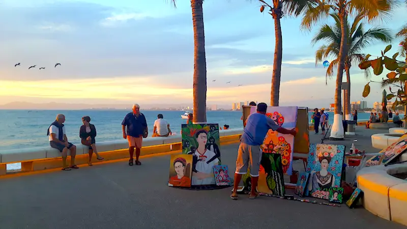 Seller with Frida Kahlo art on the malecon in Puerto Vallarta, Mexico at sunset.