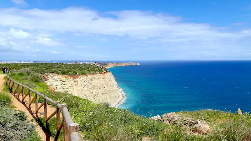 View across layered cliffs and turquoise bays from clifftop path in Lagos Portugal.