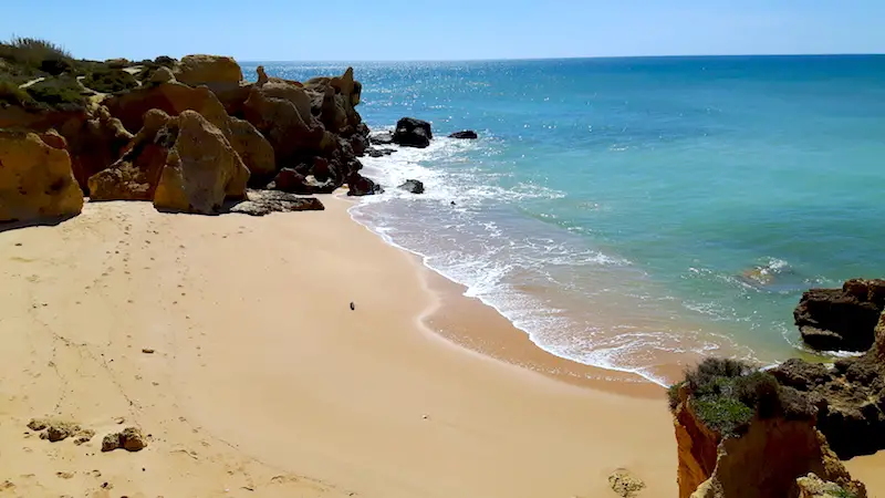 Empty golden sand beach backed by cliffs at Gale Beach, Algarve Portugal.