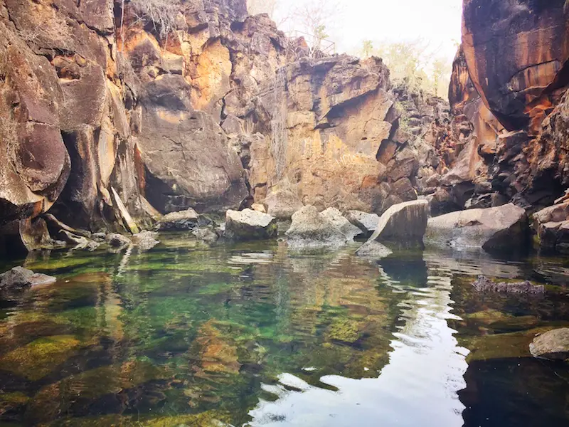 Jagged lava rock walls and clear water of Las Grietas, Galapagos Islands.