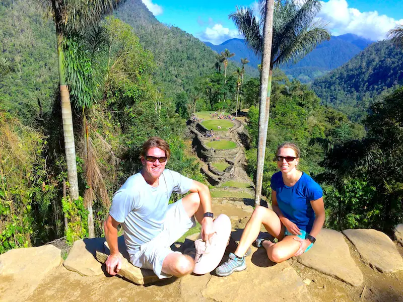 Man and woman sitting in front of the terraces of the Lost City in Colombia.