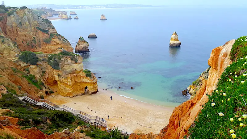 Stairs down to Praia do Camilo with rocks and cliffs in Lagos, Portugal.