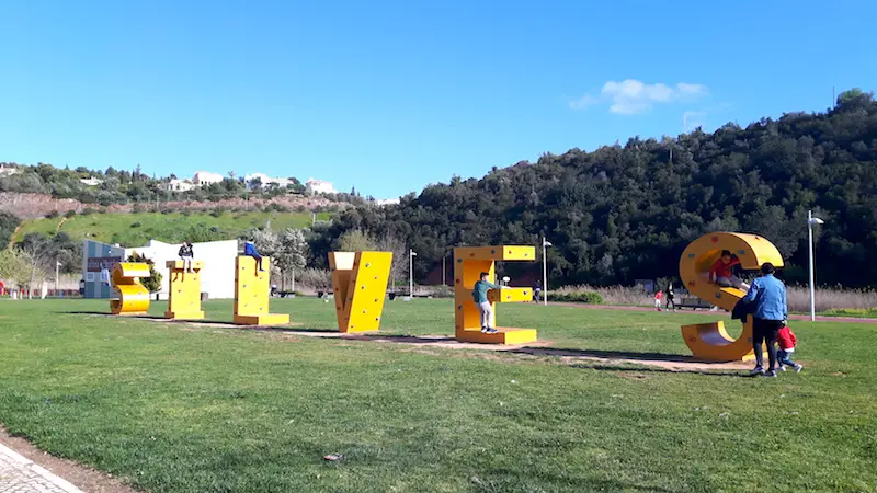 Yellow letter spelling Silves with rock climbing grips attached in Portugal.