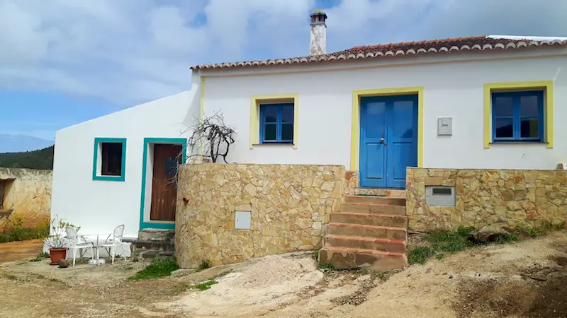 Small white houses with colourful doors in a village in Portugal.