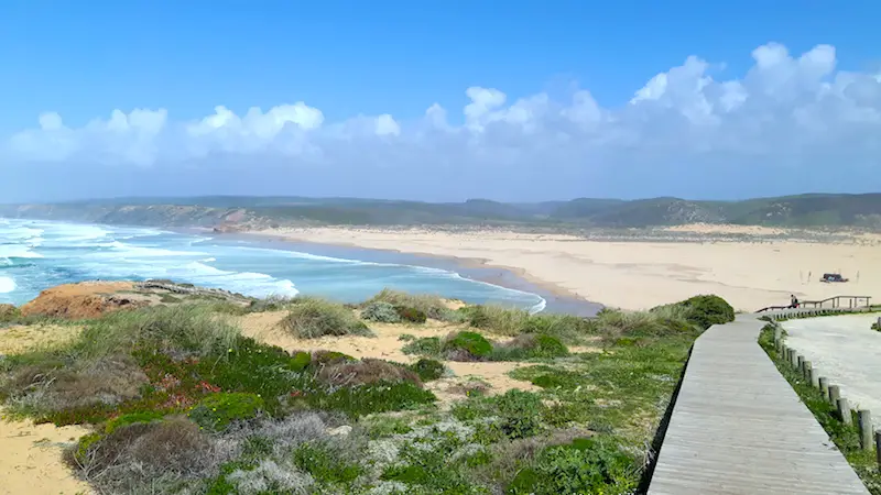 Boardwalk leading through dunes to a windswept beach in Bordeira Portugal.