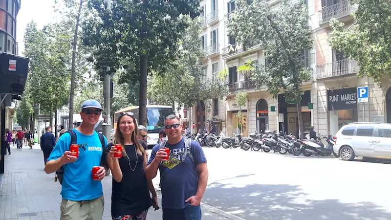 Friends on a Barcelona street with a beer each.