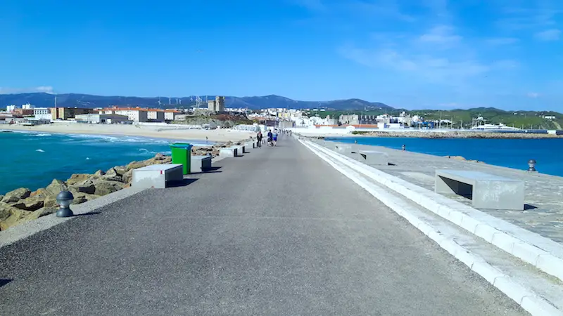 Walkway to an island with Mediterranean Sea on right and choppy Atlantic Ocean on left in Tarifa, Spain.