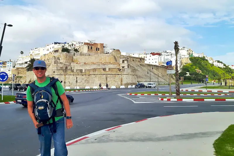 Man standing with backpacks outside Tangier Medina, Morocco.