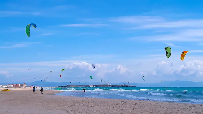 Playa los Lances filled with kites from kiteboarder in the water in Tarifa, Spain.