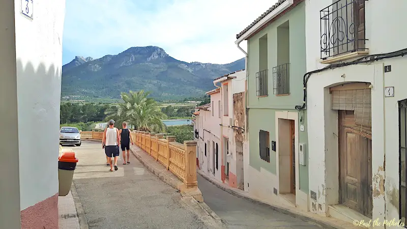 Colourful old houses with mountains and blue lake in Alcalali town in Spain.