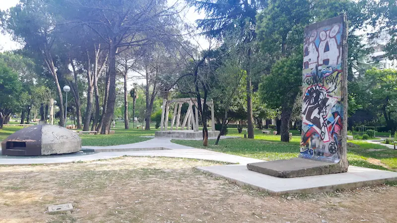 Tirana park with piece of Berlin Wall, old bunker and piece of Checkpoint Charlie on display.