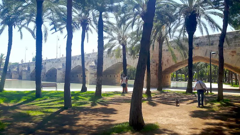 Old stone bridge crossing a dry riverbed turned into a city park in Valencia, Spain.