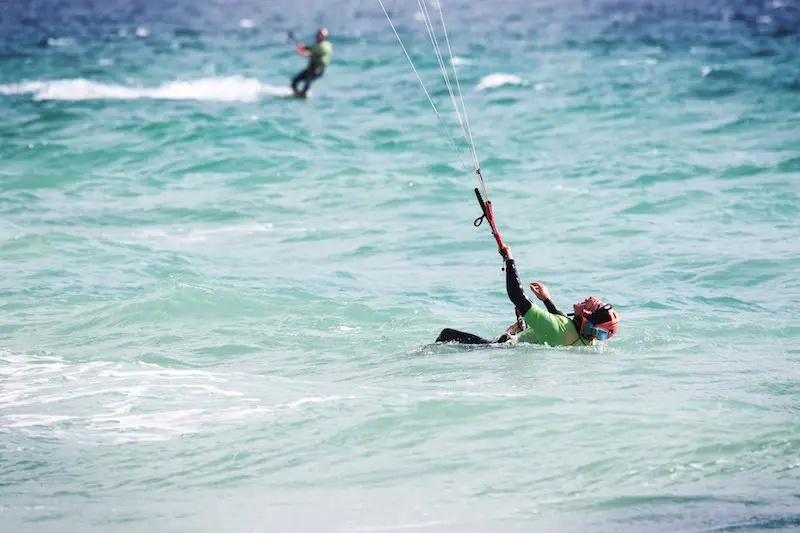 Man leaning back in the water learning to kitesurf in Tarifa, Spain.