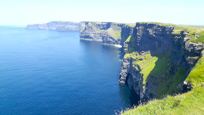 View across the rugged Cliffs of Moher and the blue Atlantic Ocean in Ireland.