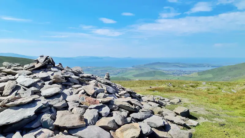 Large stack of rocks on top of Conor Pas with a stunning view across Irish landscape.