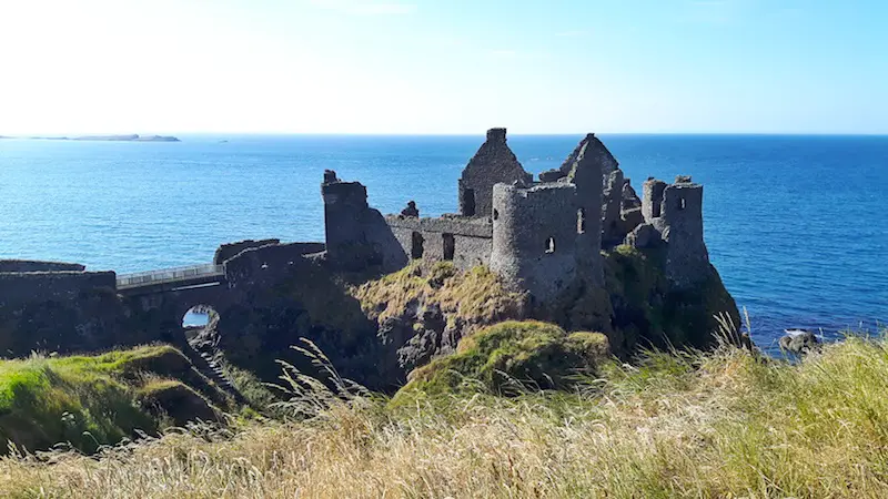 Ruins of Dunluce Castle perched on the cliff edge overlooking the sea Northern Ireland.